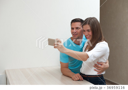 Positive young couple hugging and making selfie 36959116