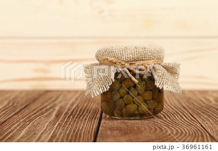 Jar of pickled green capers on table Jar of pickled green capers on table 36961161