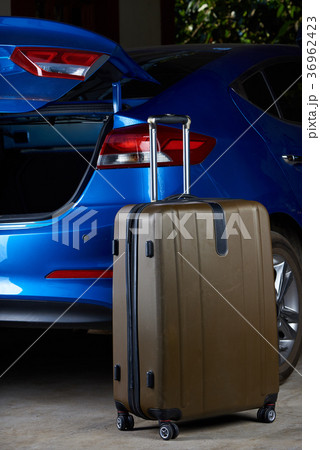 One suitcase stand next to car trunk One suitcase stand next to car trunk 36962423