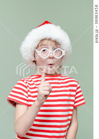 Cute boy in santa hat and glasses raised finger 36963458