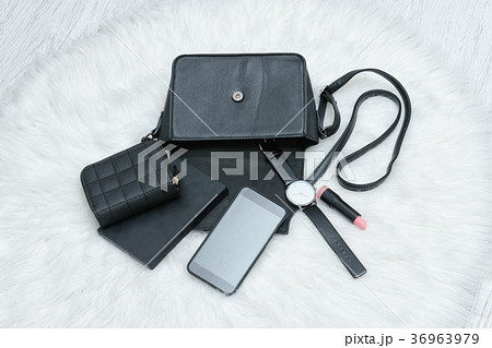 Open black bag with dropped mobile phone, watch 36963979