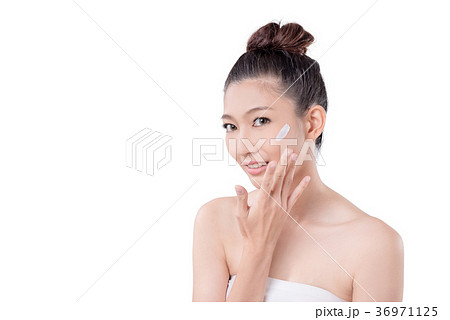 woman applying cream on face over white 36971125