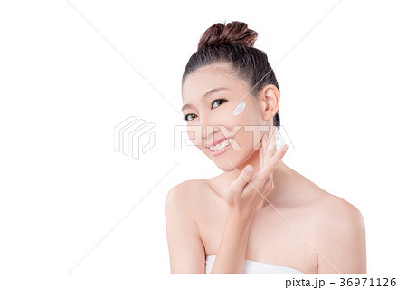 woman applying cream on face over white 36971126