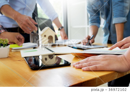 Architects Sitting Around Table Having Diverse Brainstorm Meetin Architects Sitting Around Table Having Diverse Brainstorm Meetin 36972102