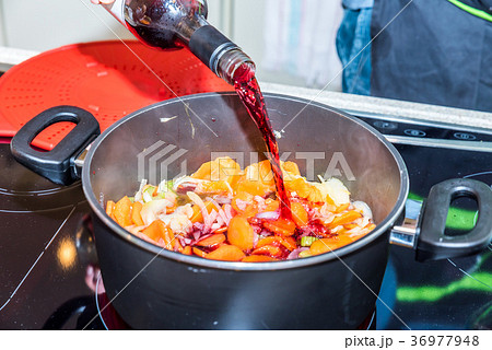 Male hand holding bottle and pouring red wine into Male hand holding bottle and pouring red wine into 36977948