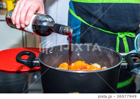 Male hand holding bottle and pouring red wine into Male hand holding bottle and pouring red wine into 36977949