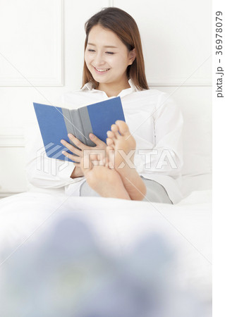若い女性 読書 ベッド 36978079