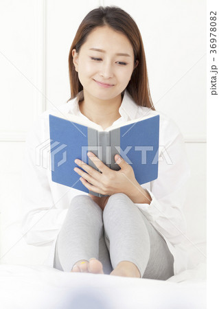 若い女性 読書 ベッド 36978082