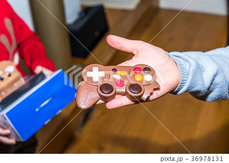 Junior hand holding gift chocolate game console 36978131
