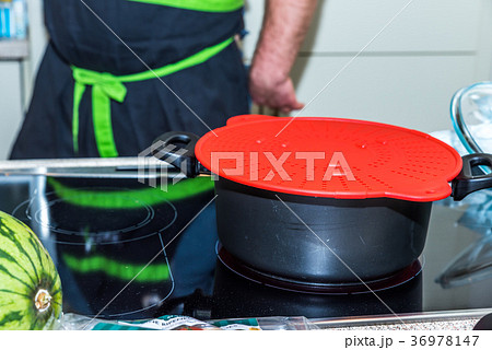 Black casserole pan with red plastic lid heating Black casserole pan with red plastic lid heating 36978147