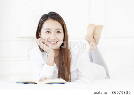 若い女性 本 ベッド 36979389