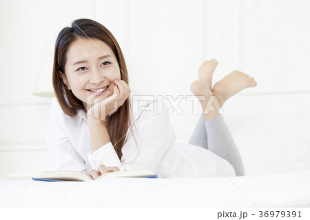 若い女性 本 ベッド 36979391