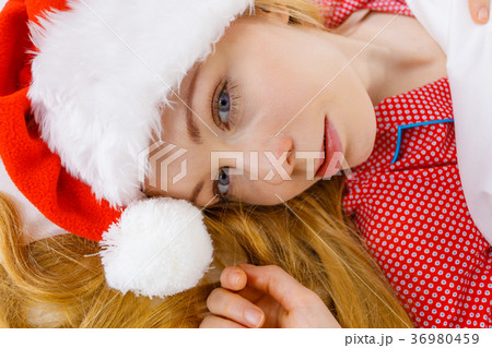 Happy woman wearing pajamas and Santa Claus hat Happy woman wearing pajamas and Santa Claus hat 36980459