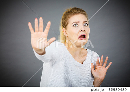 Scared woman gesturing stop gesture with hands 36980489