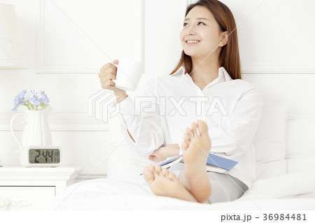 若い女性 マグカップ ベッド 36984481