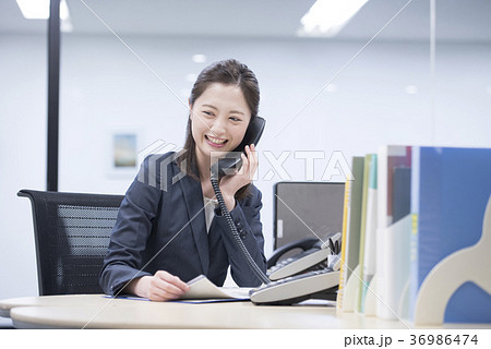 会社の電話で笑顔で話す若い女性社員 36986474