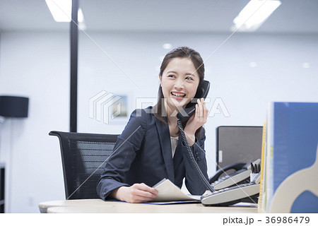 会社の電話で笑顔で話す若い女性社員 36986479