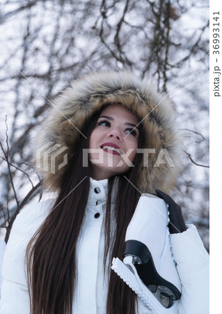 A girl in a hood with white skates on a winter 36993141