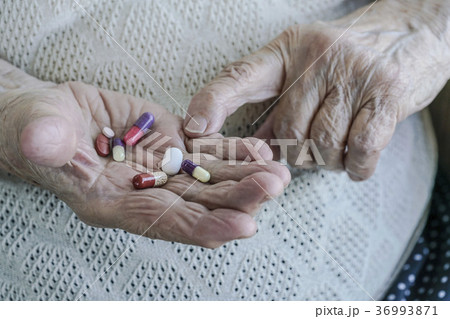 pills on palm of a senior woman 36993871
