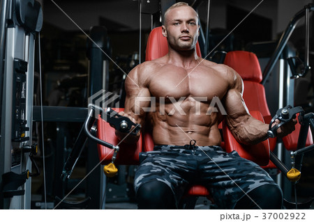 Brutal strong bodybuilder athletic men pumping up muscles with d 37002922