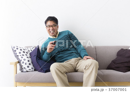 くつろいでテレビを見るミドル男性の写真素材