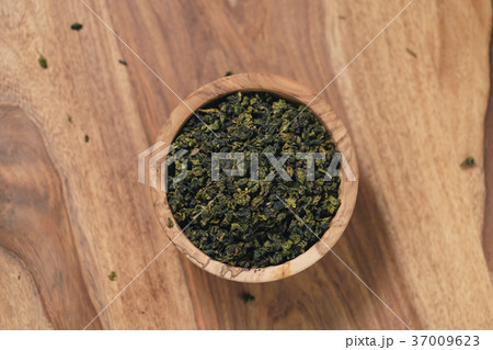 dry organic green oolong tea in wood bowl 37009623
