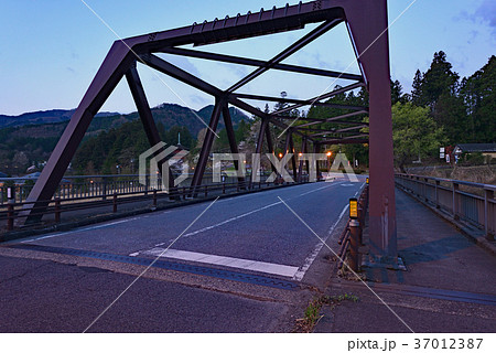早朝の静寂に佇む鉄骨の大橋 稲荷川橋から見渡す深い山々と黎明の空が織りなす風景 早朝の静寂に佇む鉄骨の大橋 稲荷川橋から見渡す深い山々と黎明の空が織りなす風景 37012387