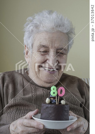 Senior woman with her birthday cake for age eighty Senior woman with her birthday cake for age eighty 37013642