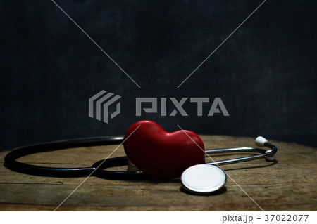 Red heart and stethoscope on a round wooden table, 37022077