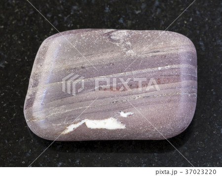polished Argillite gemstone on dark background 37023220