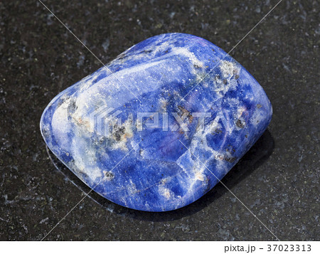 tumbled Sodalite gemstone on dark background 37023313