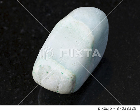 tumbled green Aragonite gemstone on dark 37023329