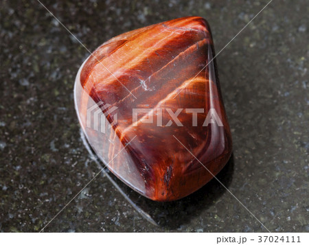polished Bull's Eye gemstone on dark background 37024111