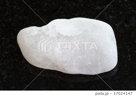 pebble of white marble on dark granite background 37024147