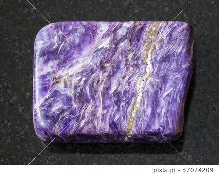 tumbled slab of charoite gemstone on dark 37024209