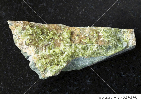 rough crystal of green Vesuvianite stone on dark 37024346