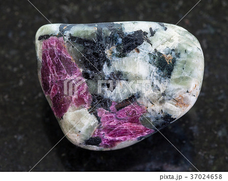 polished pink Corundum crystals in rock on dark 37024658