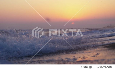 Waves at the beach in the evening at sunset 37029286