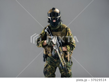 Serious man keeping assault rifle in hand 37029514