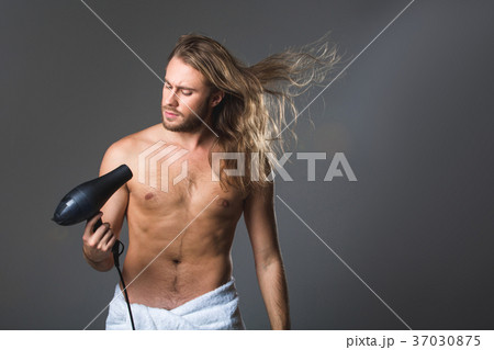 Serious man drying rainy locks 37030875