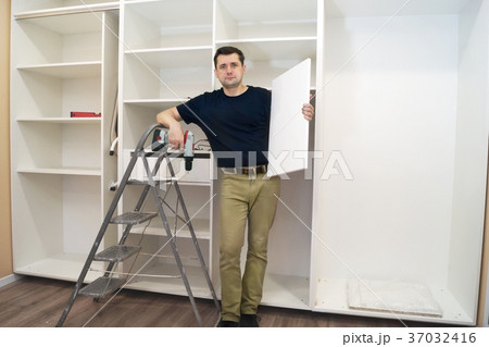 Worker with a shelf near of big cabinet. Worker with a shelf near of big cabinet. 37032416