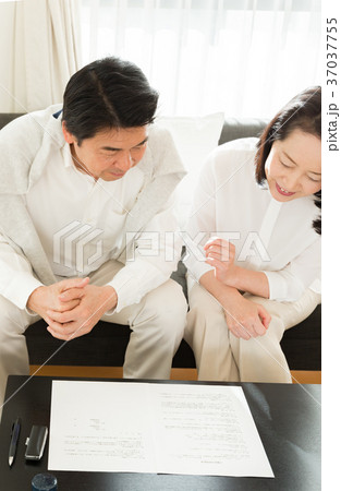 契約書を前に話し合うシニア夫婦 37037755