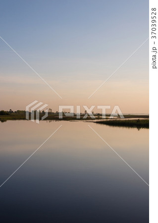 The sky in orange and blue shades is reflected. The sky in orange and blue shades is reflected. 37039528
