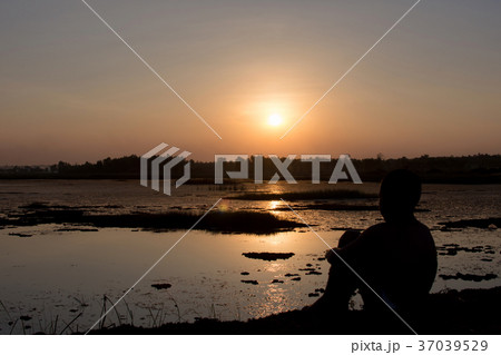 Silhouette of the boy sit hugged knees. Silhouette of the boy sit hugged knees. 37039529
