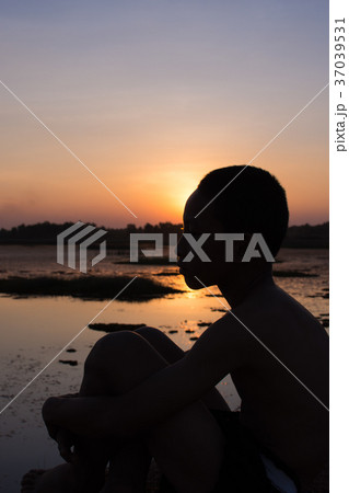 Silhouette of the boy sit hugged knees. Silhouette of the boy sit hugged knees. 37039531