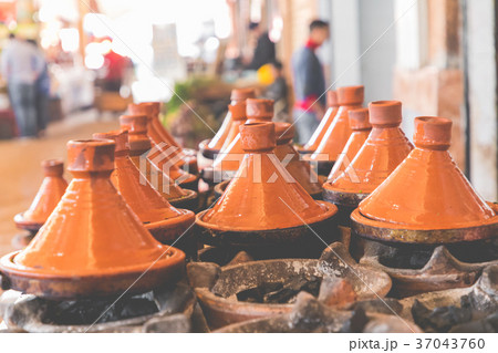 Preparing food in tajin traditional dish, Morocco Preparing food in tajin traditional dish, Morocco 37043760