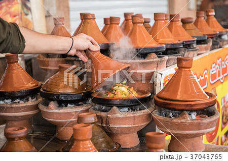 Preparing food in tajin traditional dish, Morocco 37043765