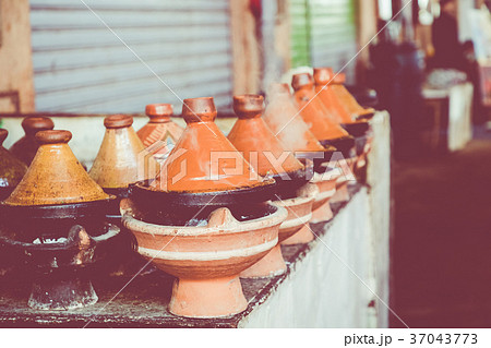 Preparing food in tajin traditional dish, Morocco Preparing food in tajin traditional dish, Morocco 37043773