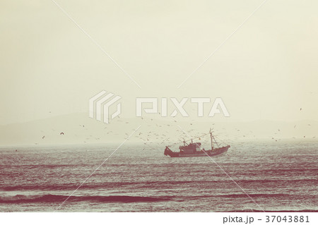 Fishing boat with sunset in the background Fishing boat with sunset in the background 37043881