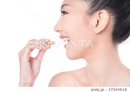 Woman eating vitamin over white background 37044618